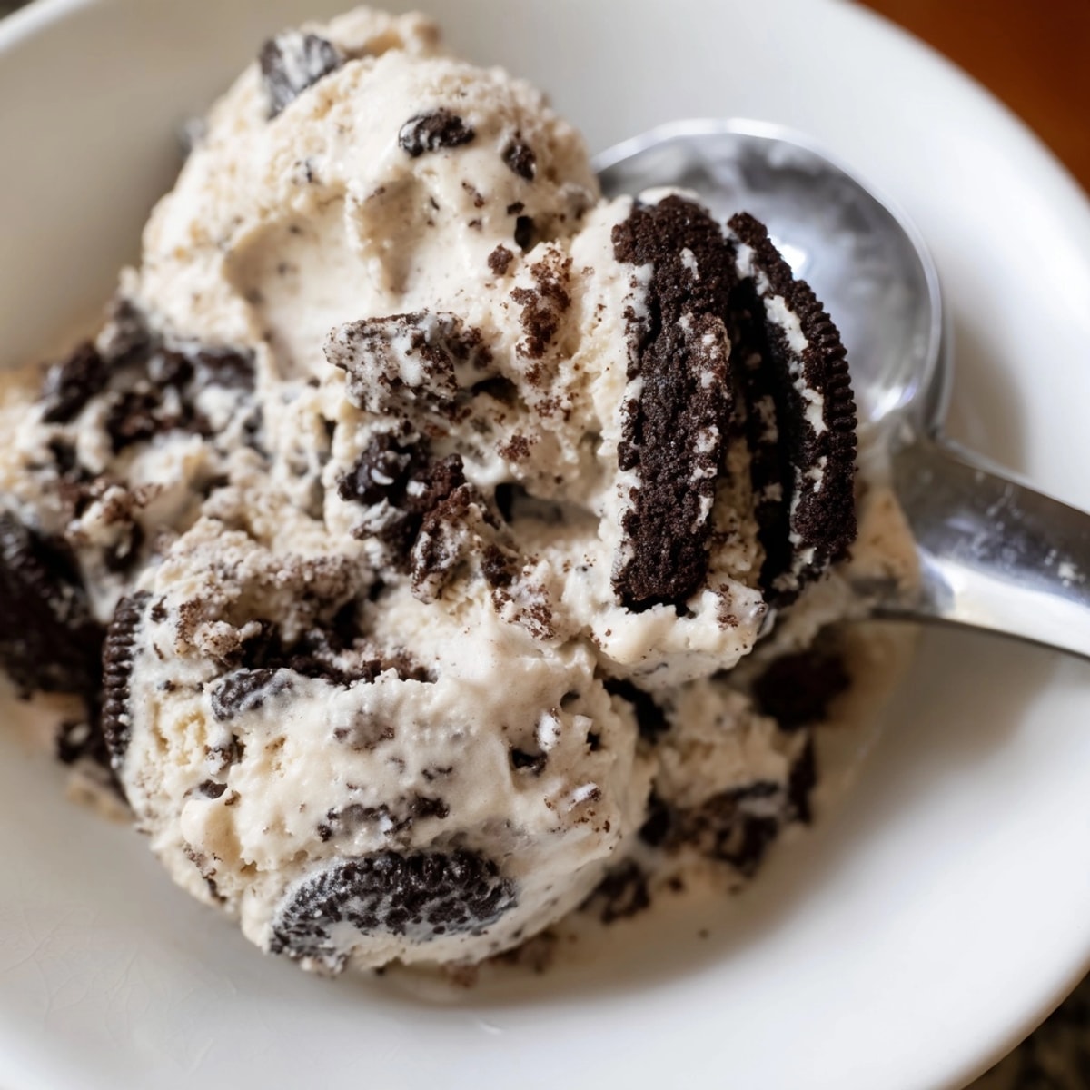 Scoops of rich, homemade Cookies and Cream Ice Cream with chunks of cookie visible.