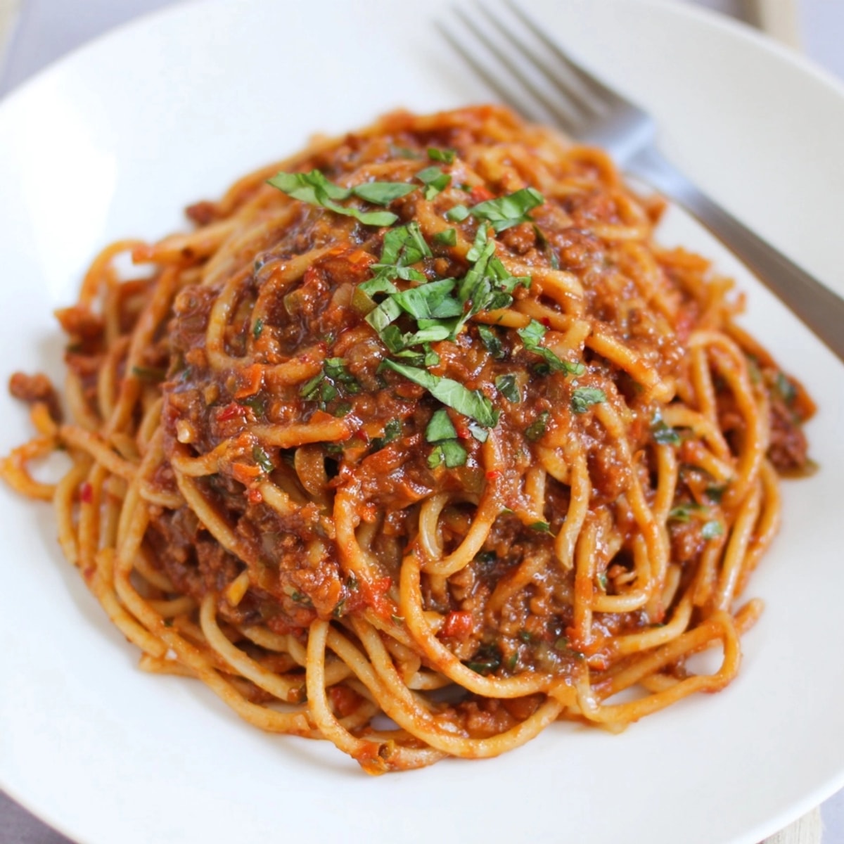 Close-up of rich, simmering Impossible Burger Bolognese sauce, ready to toss with pasta.