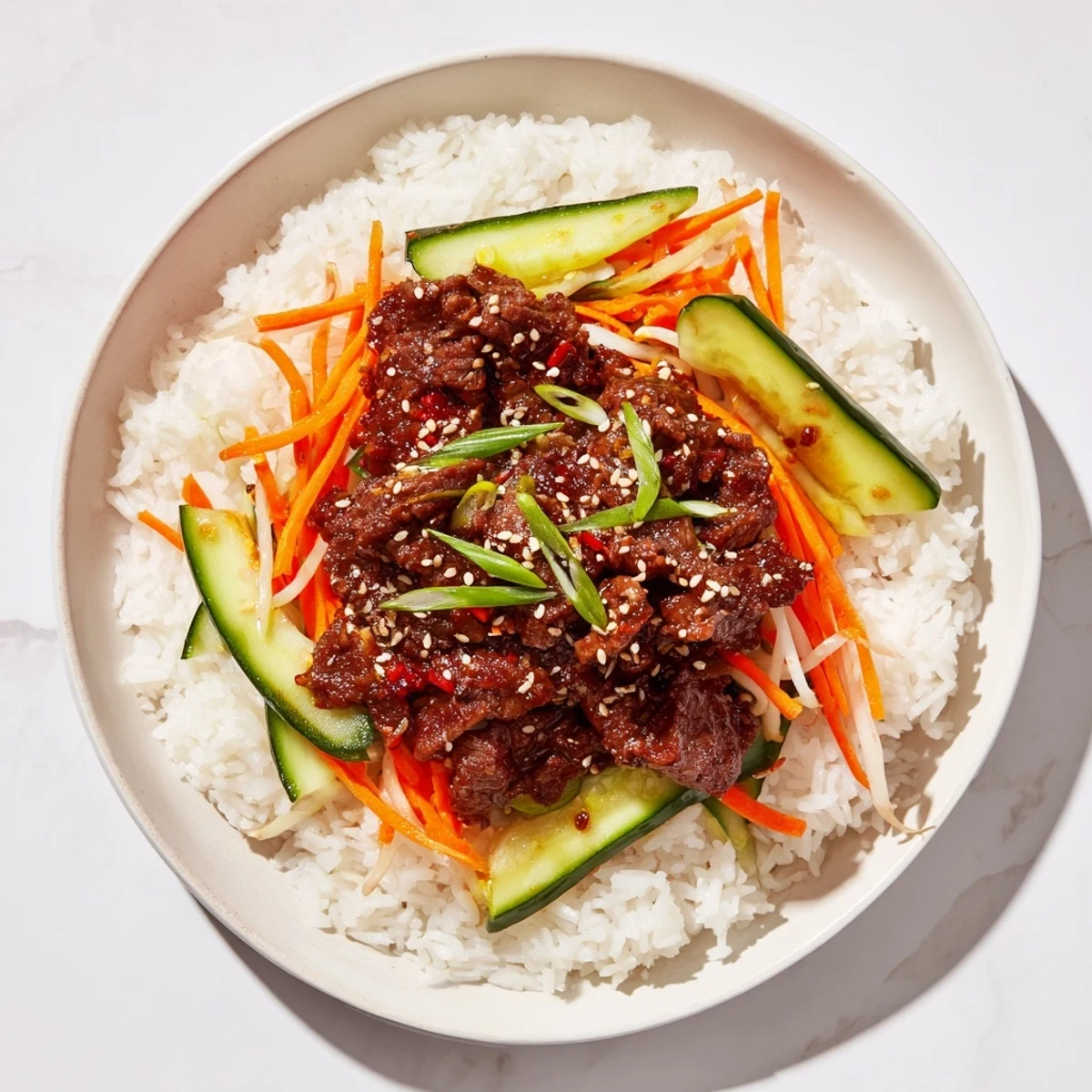 Steaming Spicy Korean Beef Bowl served over rice, garnished with fresh scallions and sesame seeds.