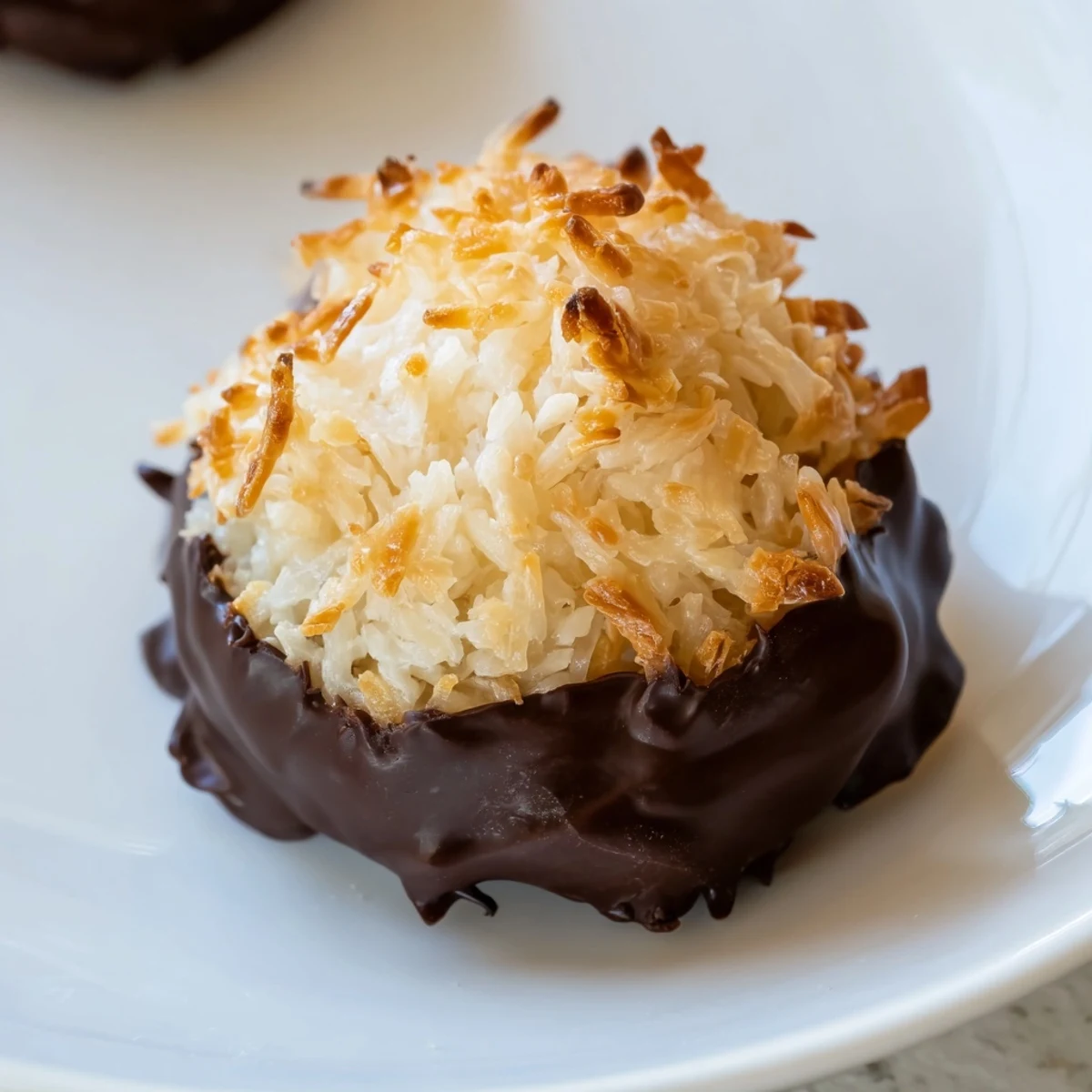 A close-up of decadent Chocolate Covered Coconut Macaroons, ready to be enjoyed as a sweet treat.