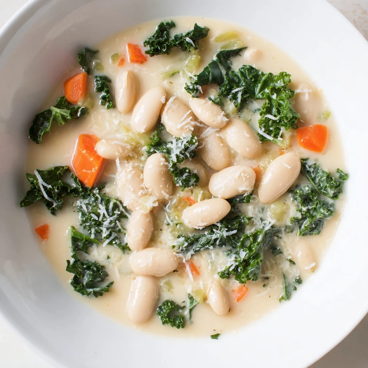 Close-up of a rustic, hearty creamy white bean and kale soup, showcasing the fresh kale and creamy texture.
