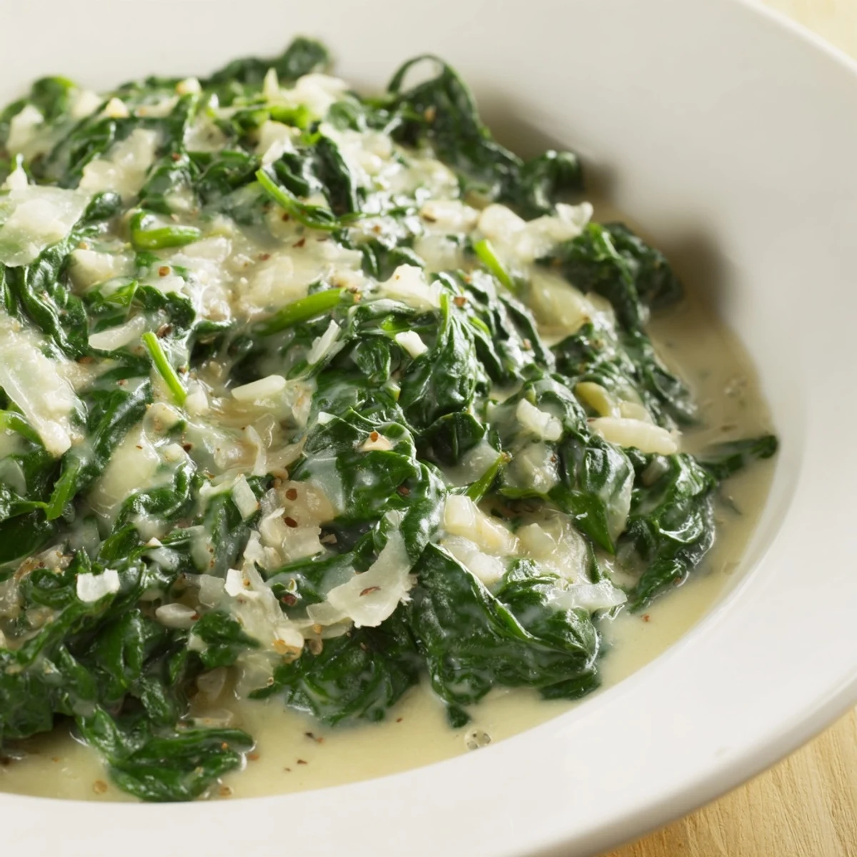 Spoonful of the creamy spinach side showcases a smooth, velvety texture mixed with seasonings.