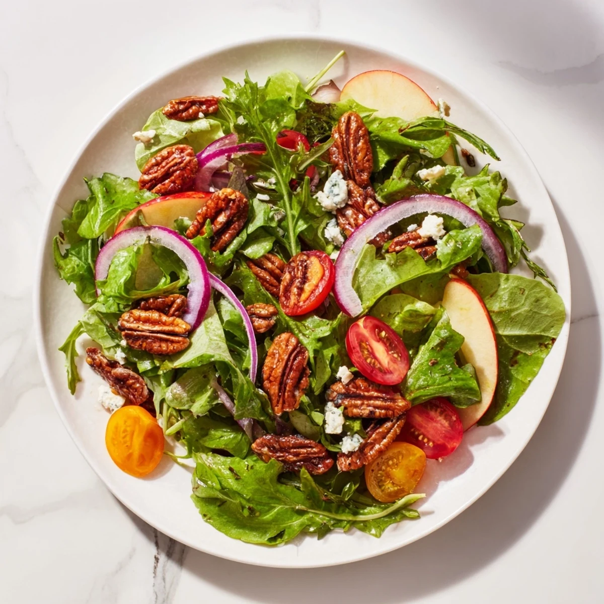 A close-up of a Pecan Salad with goat cheese crumbles, ready to be enjoyed as a meal.