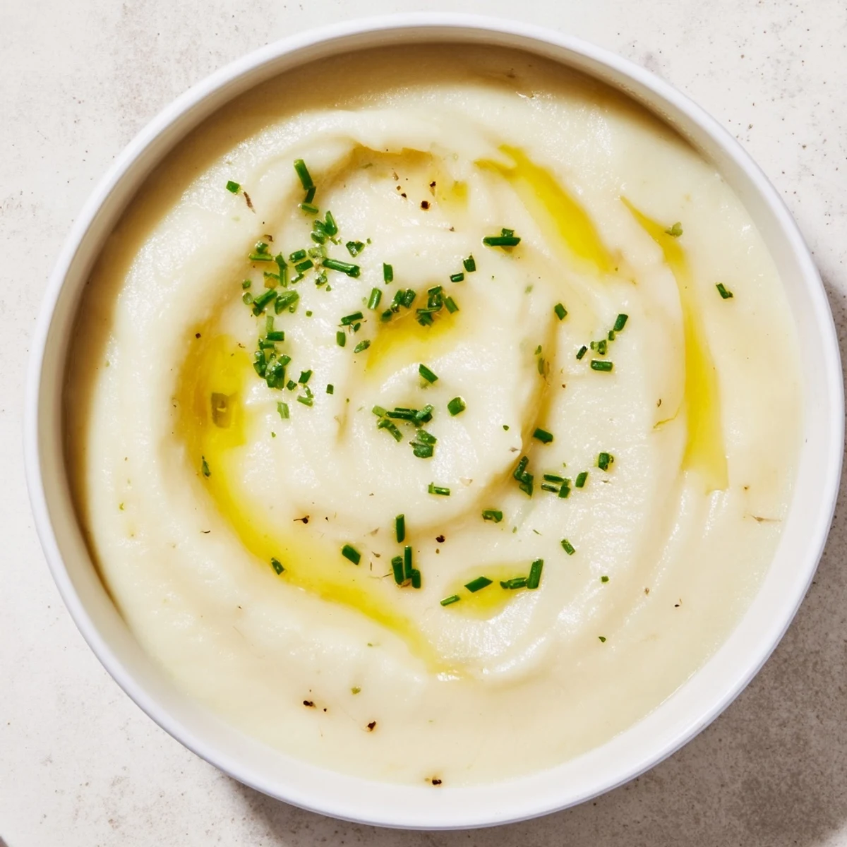 Creamy Cauliflower and Truffle Soup, garnished with chives, a luxurious and savory vegetarian soup.