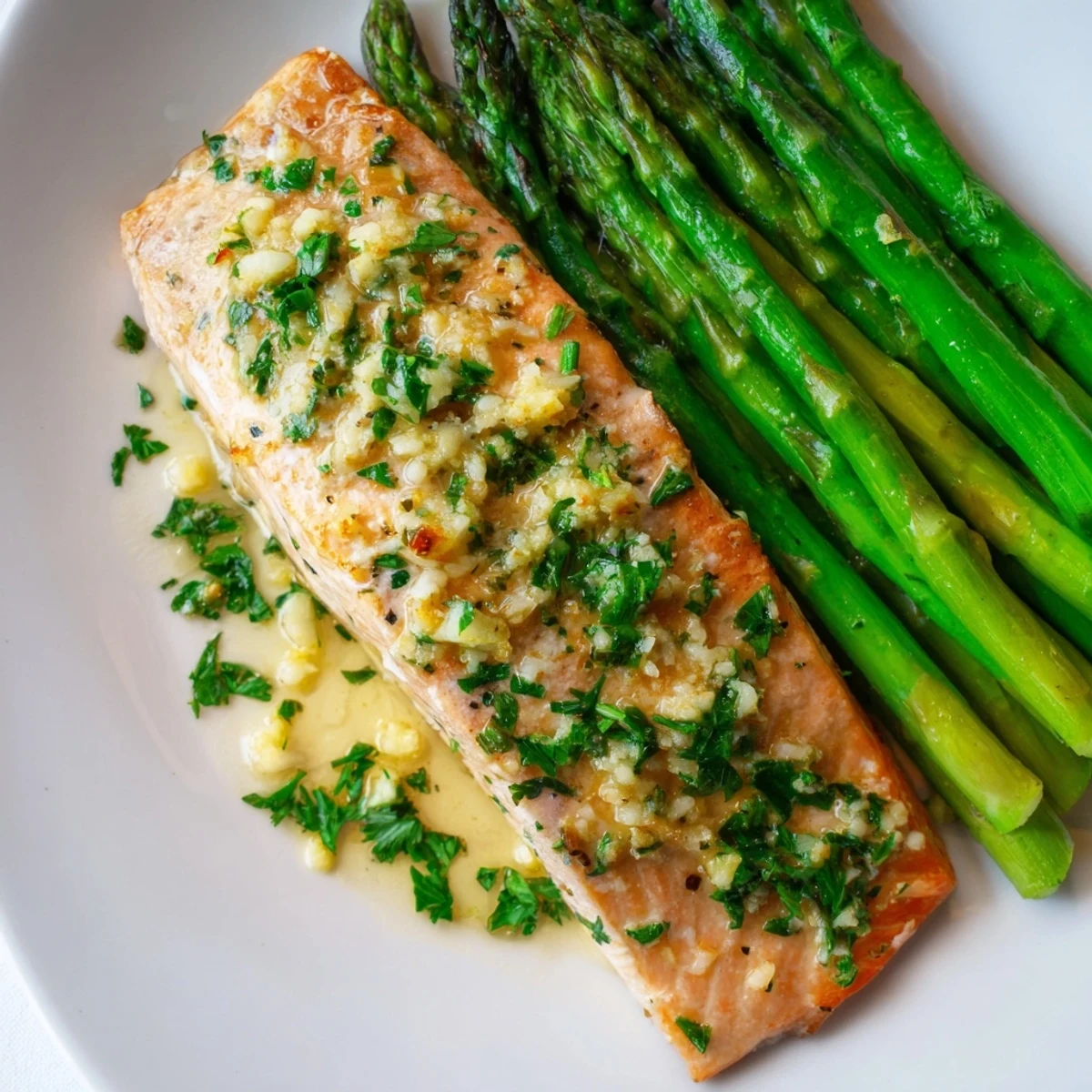 Golden, flaky Lemon Garlic Butter Salmon fillets, accompanied by vibrant asparagus, ready to be enjoyed.