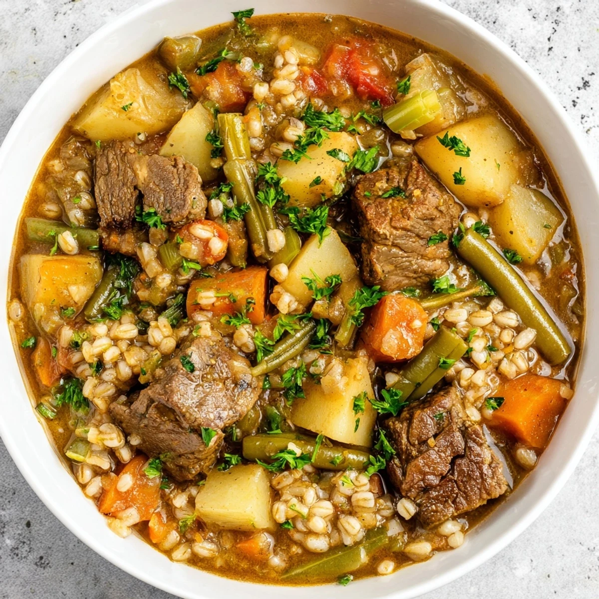 Spoonful of flavorful Hearty Beef and Barley Vegetable Stew, rich with herbs and meltingly soft beef.