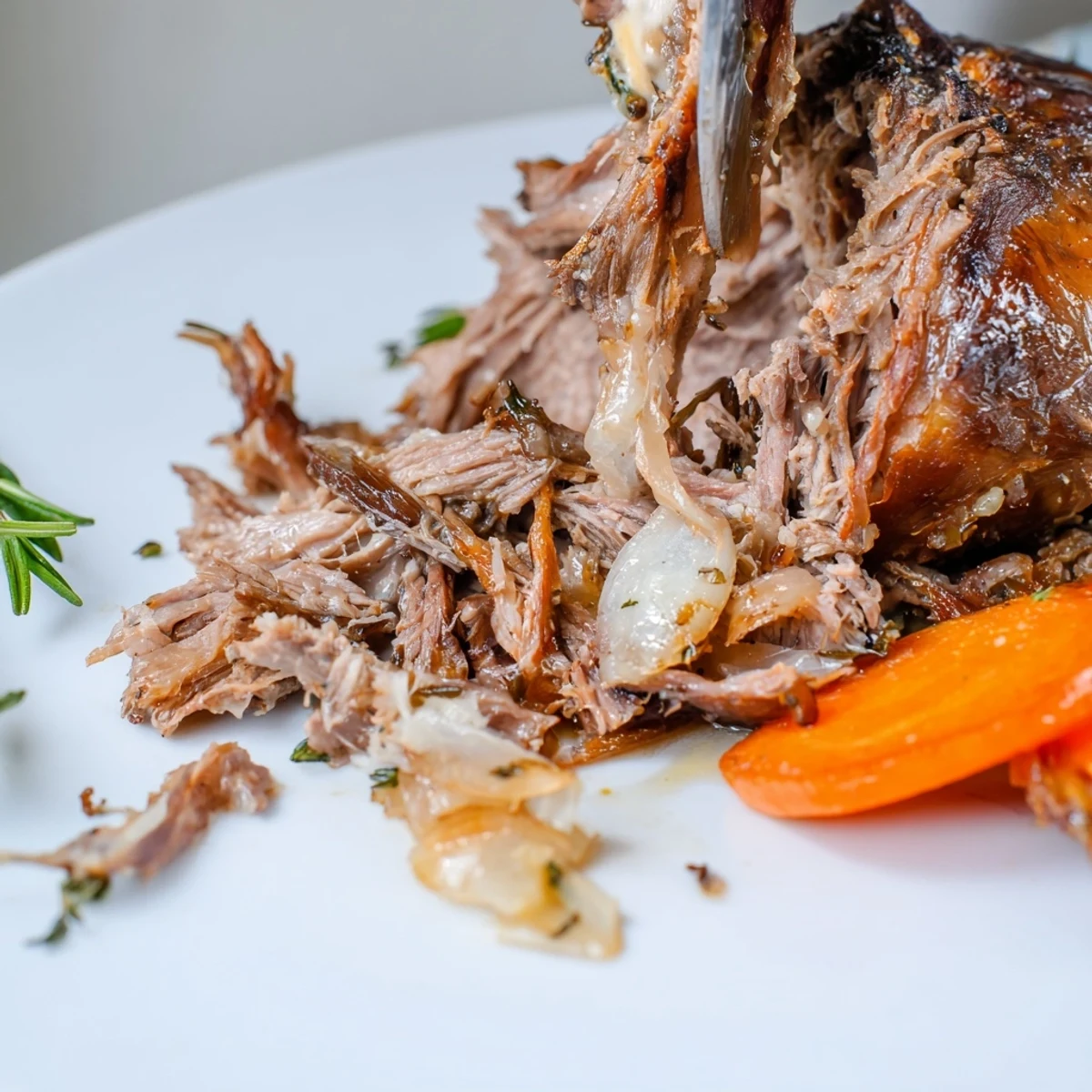 A golden-brown lamb shoulder, freshly pulled from the oven, glistening with savory pan juices. Fresh herb sprigs and lemon zest garnish this succulent, gluten-free dinner.