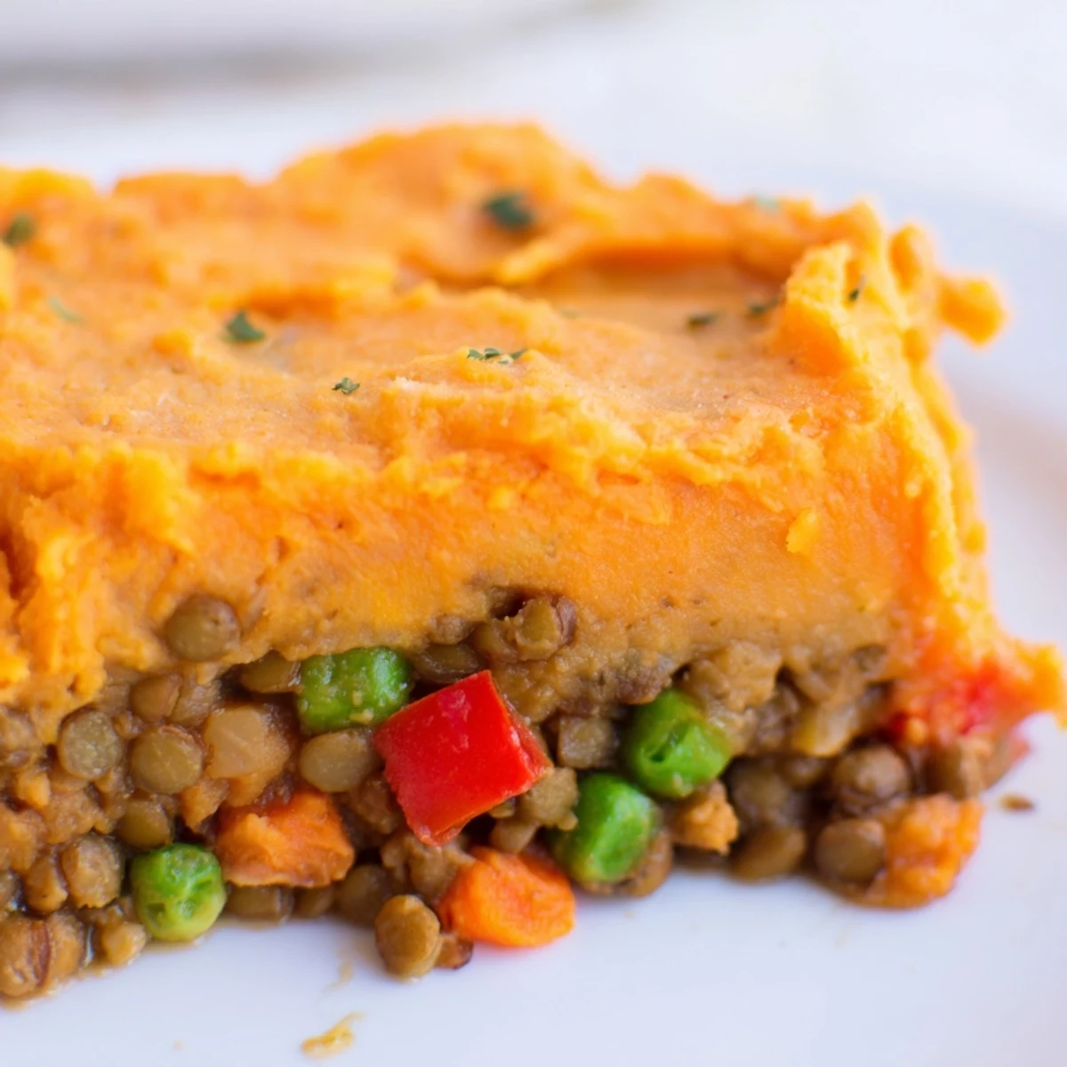 Steam rises from a casserole dish of Vegan Lentil and Sweet Potato Shepherds Pie, ready for a comforting family dinner.