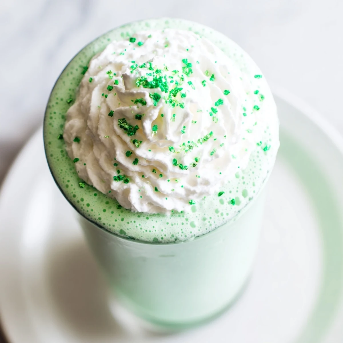 Refreshing Shamrock Mint Milkshake garnished with a maraschino cherry, perfect for St. Patrick's Day celebrations.  