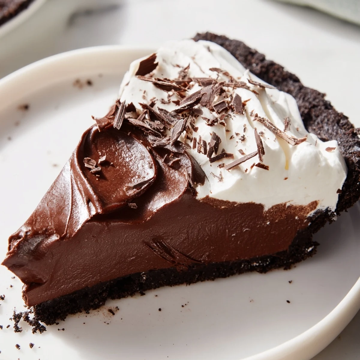 Romantic Chocolate Silk Pie with velvety chocolate filling and whipped cream topping on a rustic wooden table.