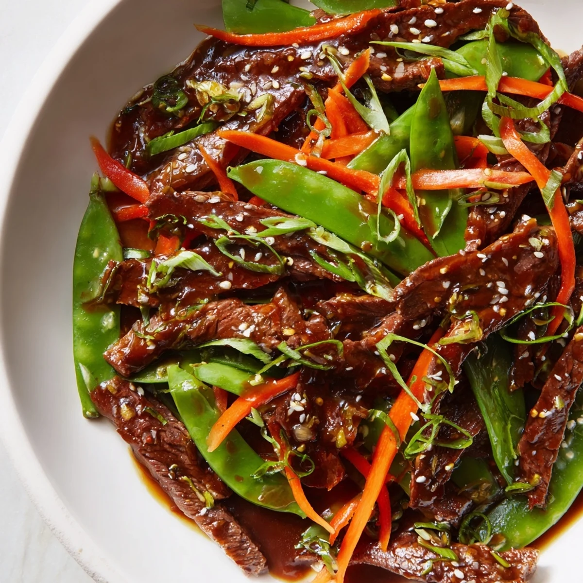 Tender beef strips and crisp snow peas in a savory Beef Stir Fry with Snow Peas and Carrots served over white rice.