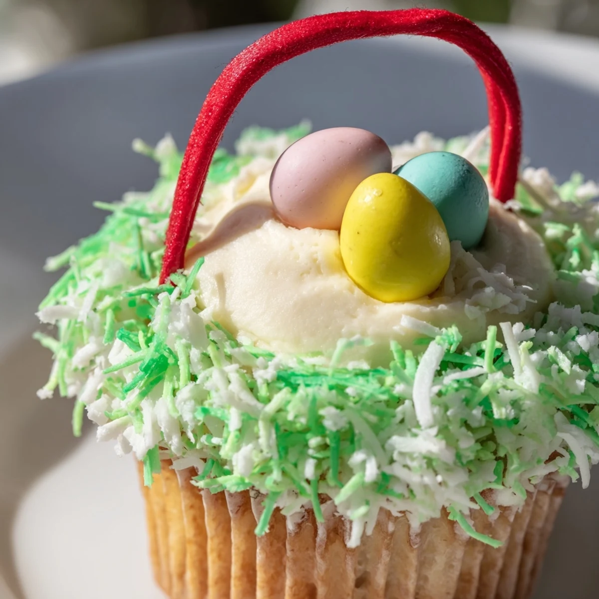 Frosted Easter Basket Cupcakes with licorice handles and pastel candy eggs arranged on a spring dessert table.