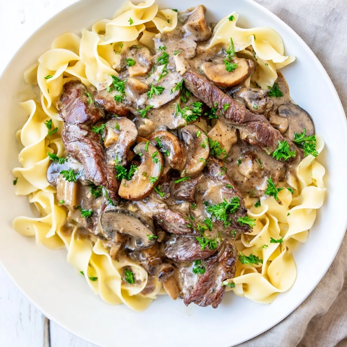 Savory Beef Stroganoff with Egg Noodles featuring golden noodles coated in rich, velvety sauce for a comforting meal.