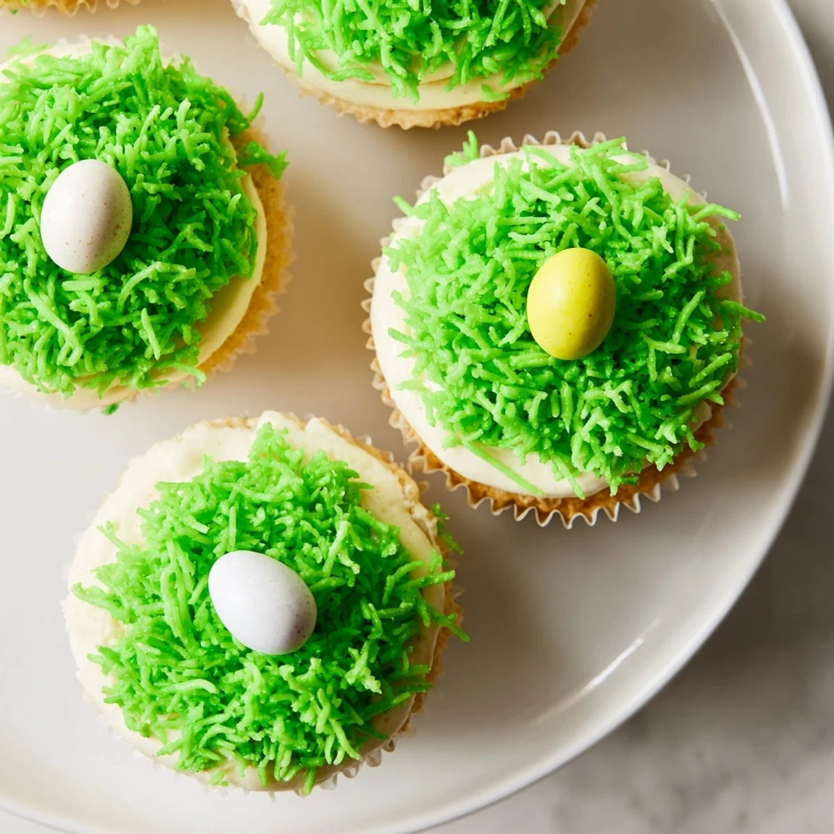 Moist Easter Basket Cupcakes with Coconut Grass topped with sweet shredded coconut and pastel candy eggs for Easter brunch.