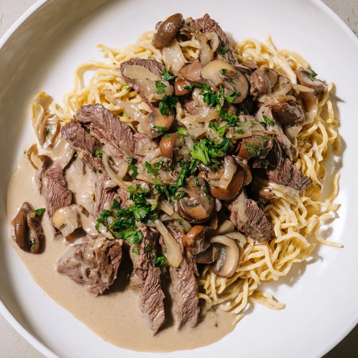 Tender strips of beef in creamy mushroom sauce over buttery egg noodles, a classic Beef Stroganoff for dinner.