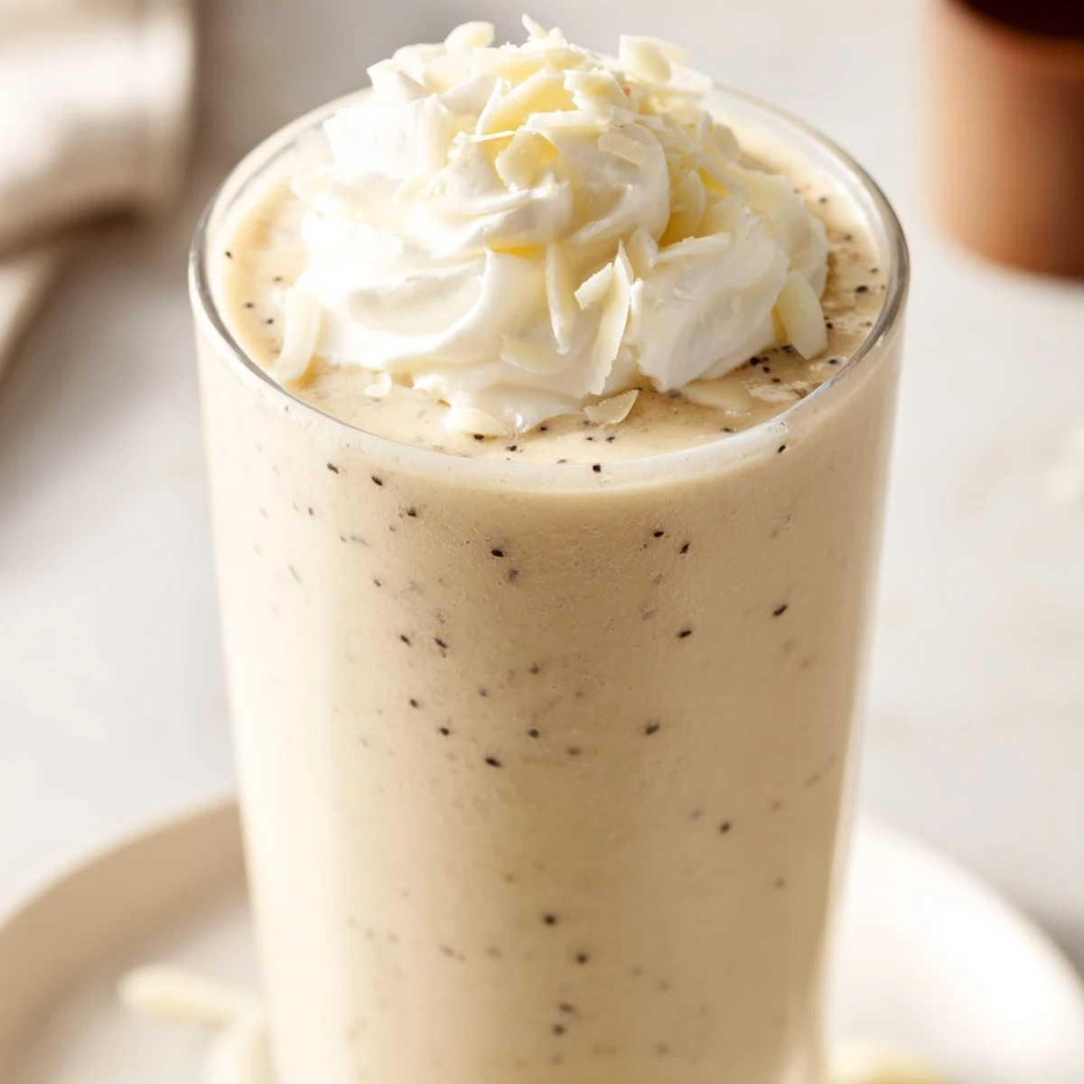 Cold Vanilla Bean Frappuccino in a clear glass, showing creamy swirls and a frothy finish.
