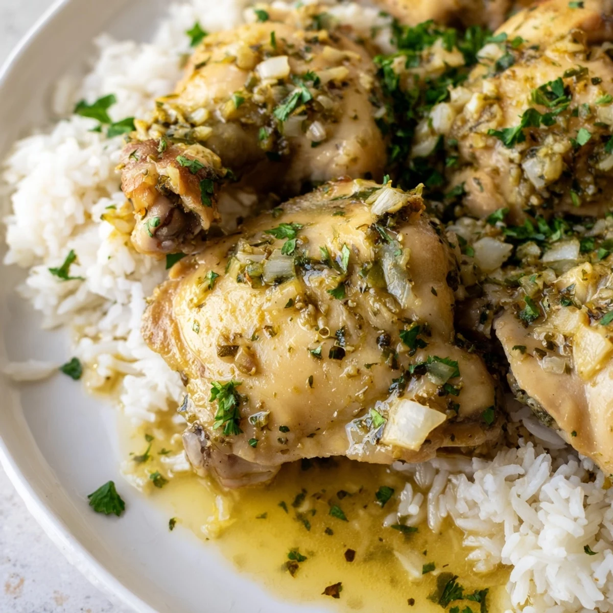 Comforting slow cooker lemon herb chicken plated over steaming fluffy rice, spooned with savory juices and fresh herb garnish.