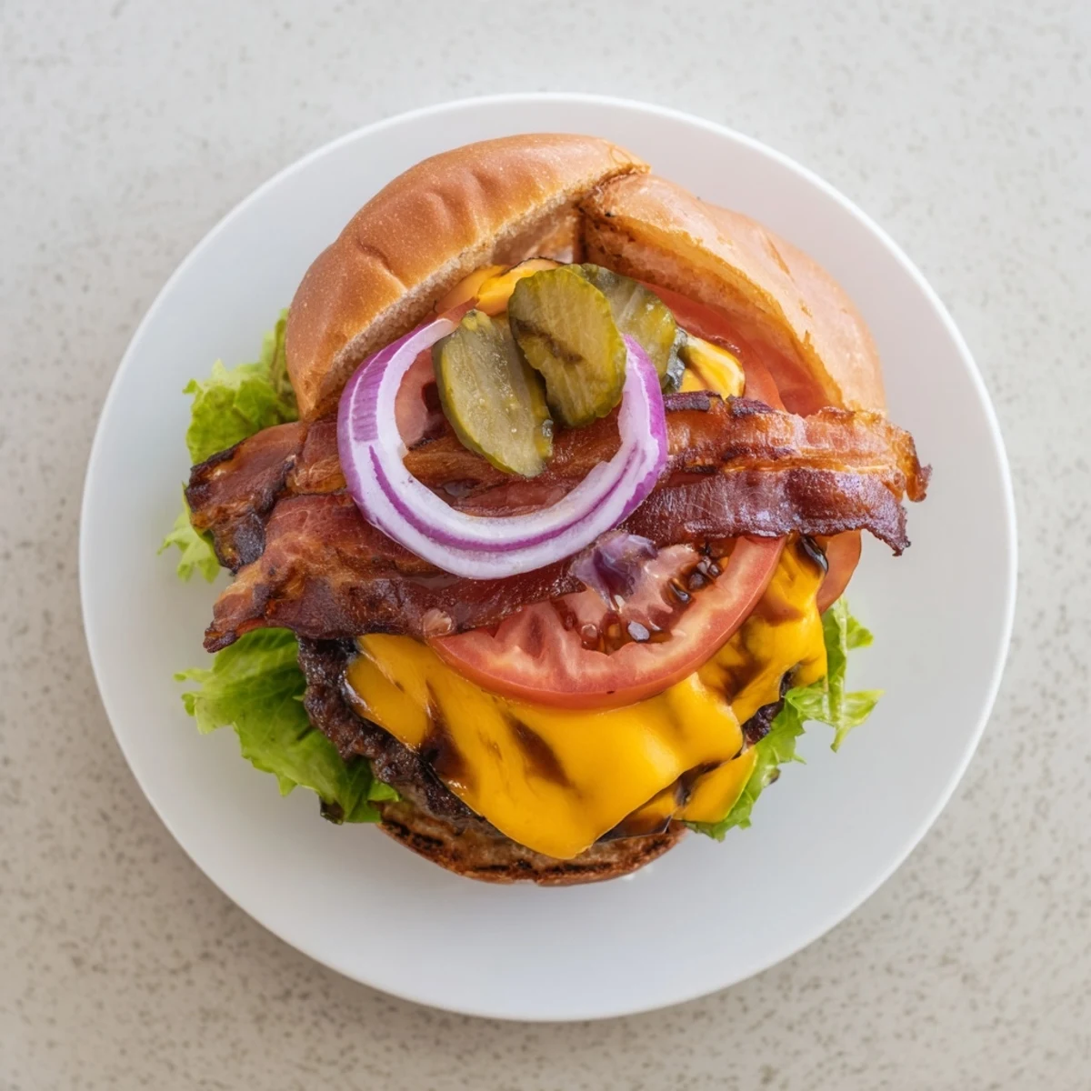 Juicy hearty BBQ bacon burger stacked with melted cheddar and crispy bacon strips on toasted brioche bun