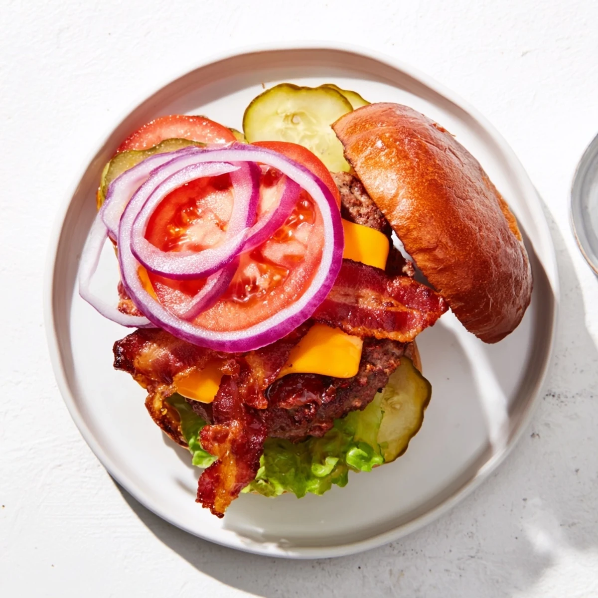 Mouthwatering hearty BBQ bacon burger featuring cheese melted patty crunch bacon and dill pickle on golden bun