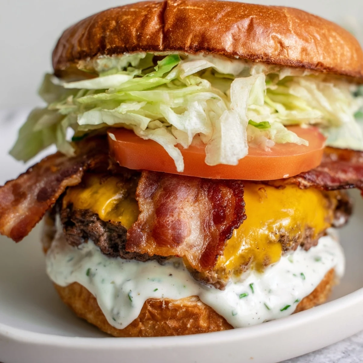 Juicy Crack Burgers stacked with crispy bacon, melted cheddar, and tangy ranch-mayo sauce on toasted brioche buns