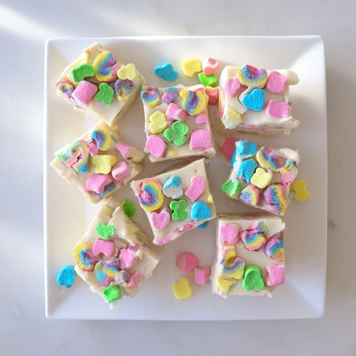 Handheld easy Lucky Charms fudge piece showing swirled white chocolate and bright crunchy marshmallow toppings
