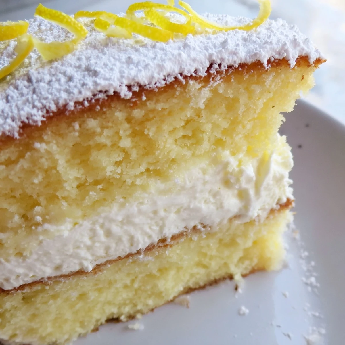 Sliced Italian Lemon Cream Cake revealing tender lemon-infused layers and creamy mascarpone filling inside