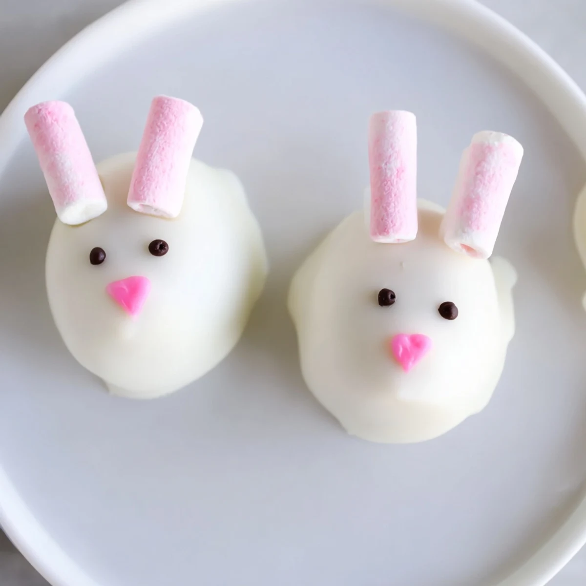 Adorable white chocolate bunny Oreo balls with marshmallow ears and tails arranged on a platter