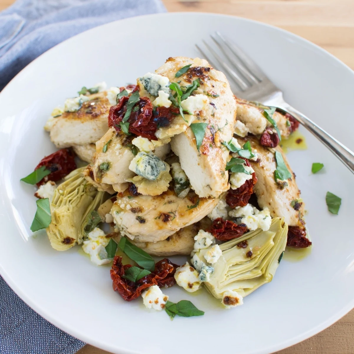 Juicy broiled artichoke chicken with bubbling feta topping and fresh herbs