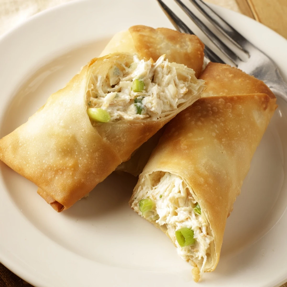 Golden brown crispy Crab Rangoon Egg Rolls filled with creamy crab and cream cheese