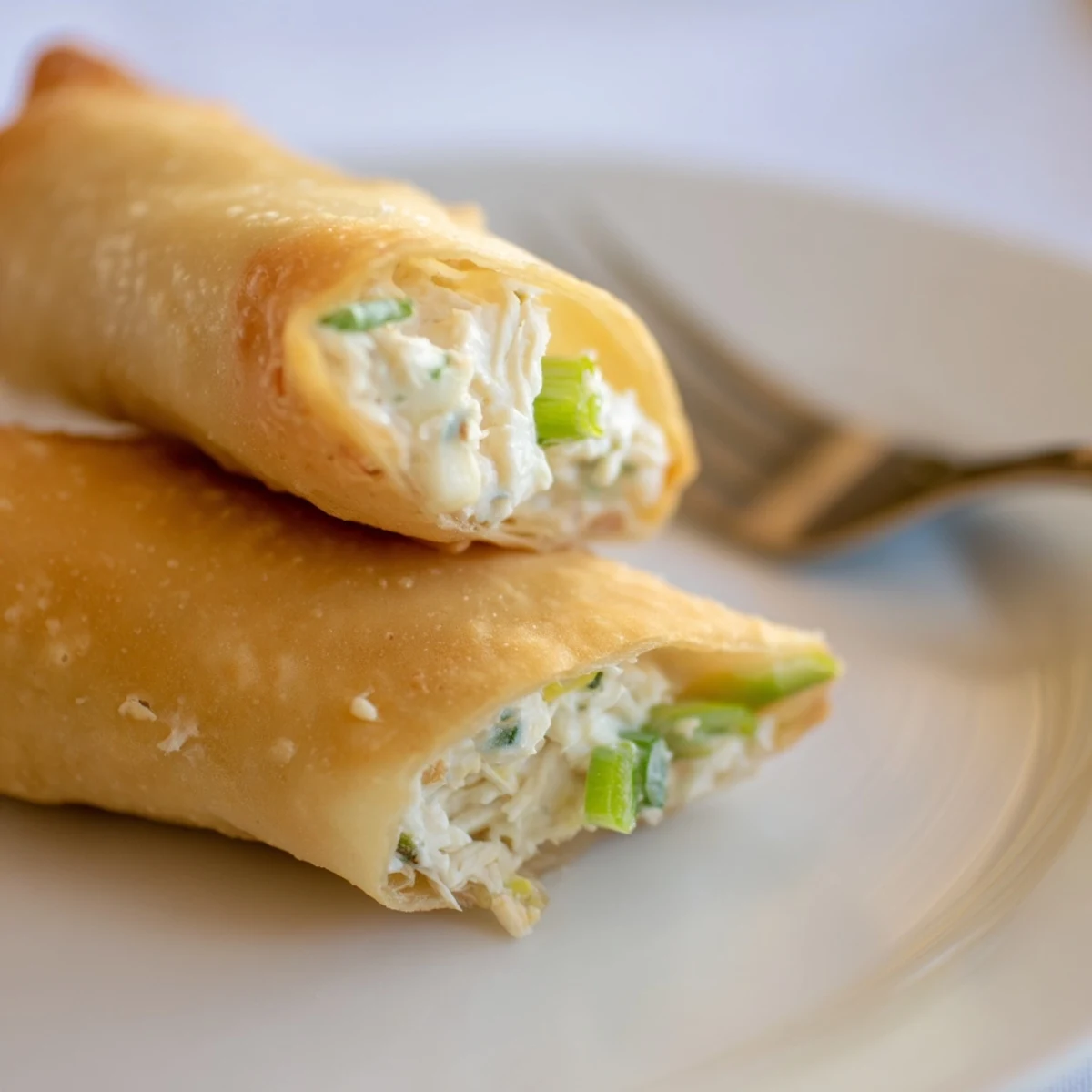 Fried Crab Rangoon Egg Rolls served on white plate with sweet chili dipping sauce