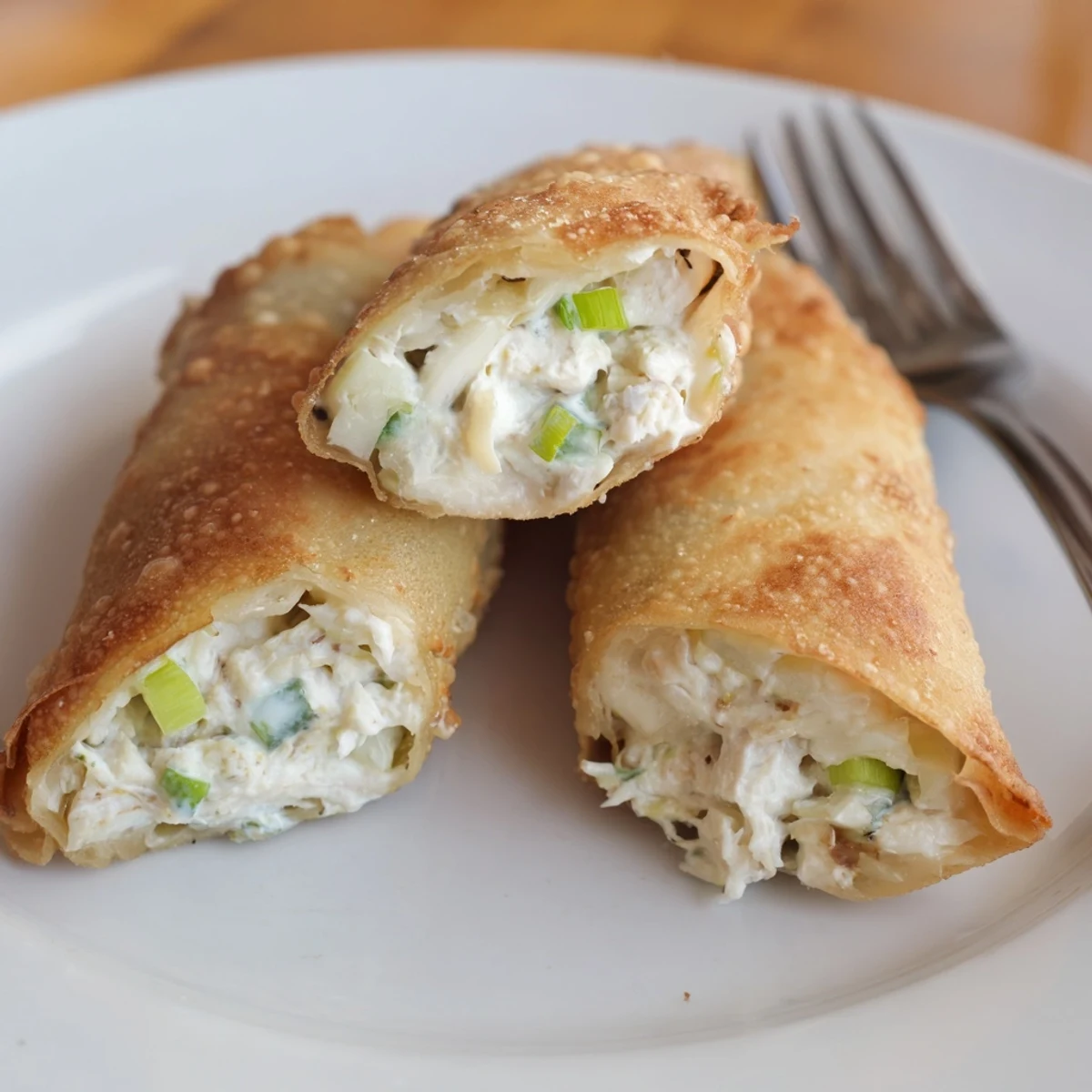 Plate of golden Crab Rangoon Egg rolls showcasing crisp texture and savory filling