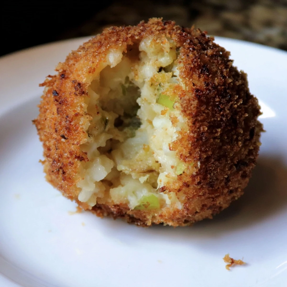 Bubbling melted cheese center revealed in a halved Cheesy Fried Colcannon Ball appetizer