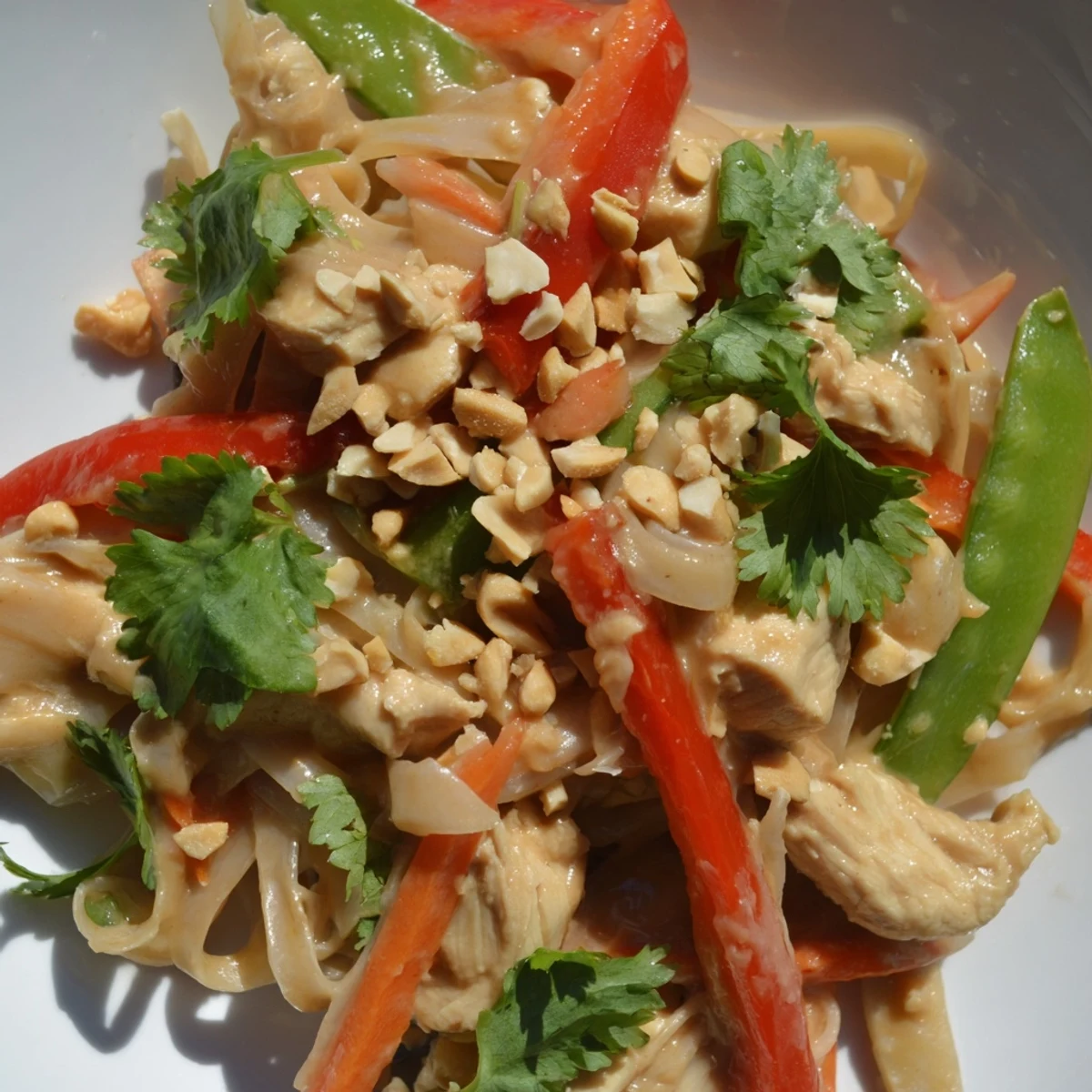 Golden chicken strips and crisp vegetables stir-fried in rich Thai peanut chicken noodle bowls with creamy sauce