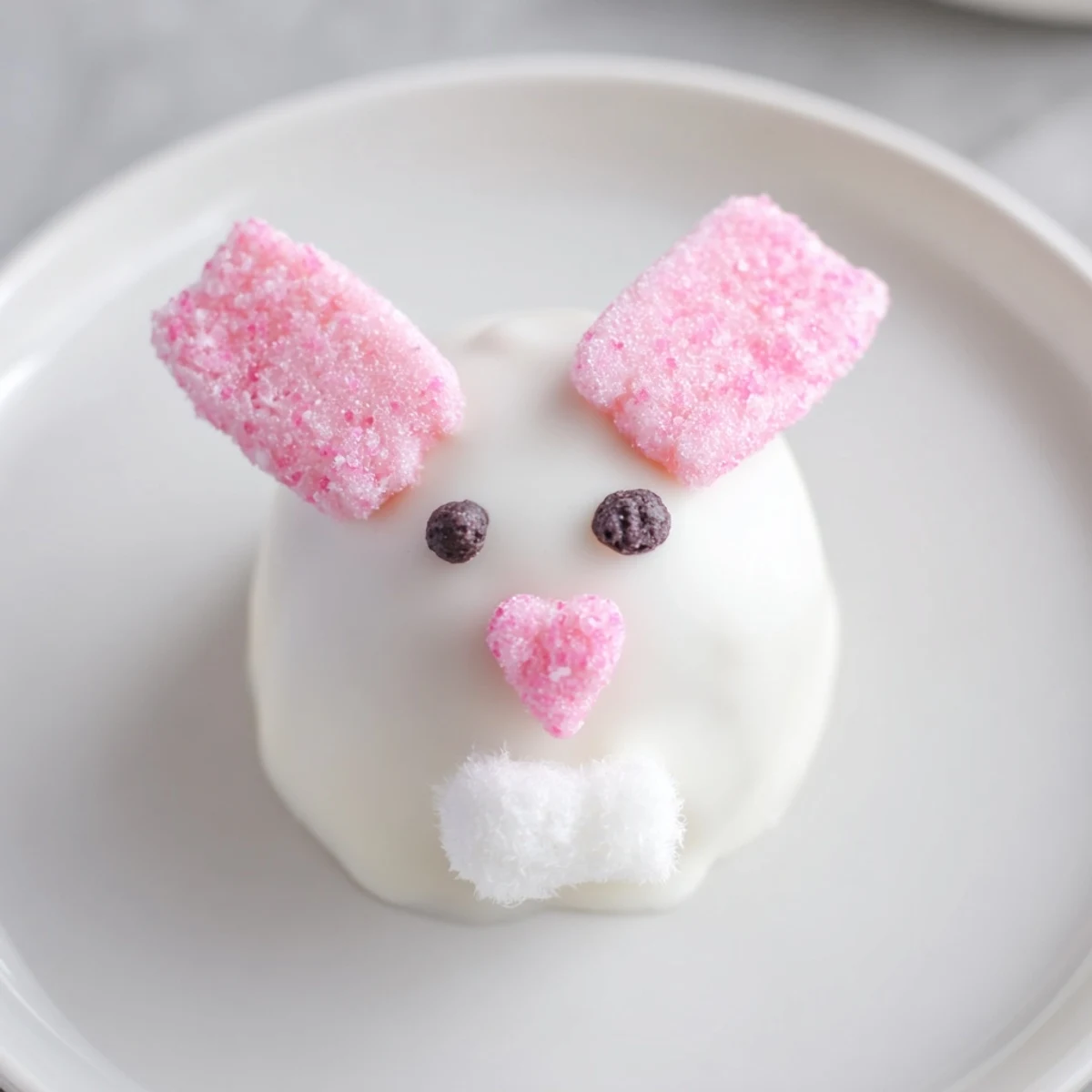 White chocolate coated Oreo balls decorated as Easter bunnies with pink ears and edible eyes