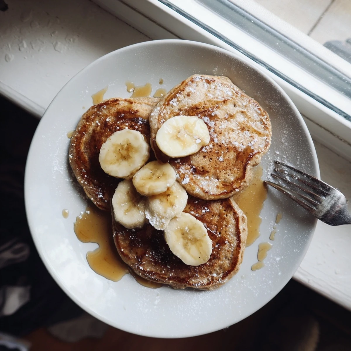 Protein-rich Greek yogurt banana pancakes stacked high with honey drizzle and berries on top