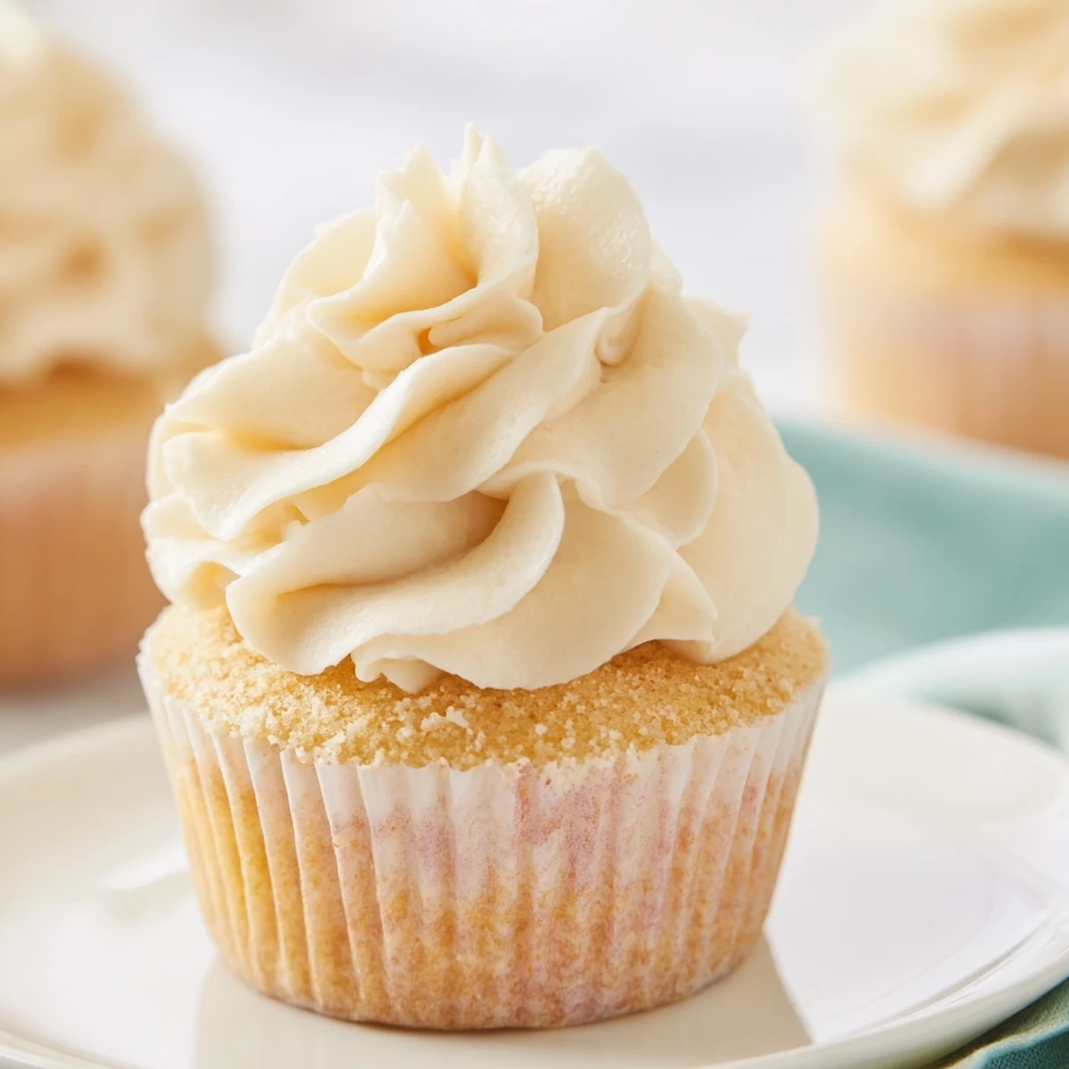 Light and airy vanilla cupcakes with smooth creamy frosting piped in elegant peaks