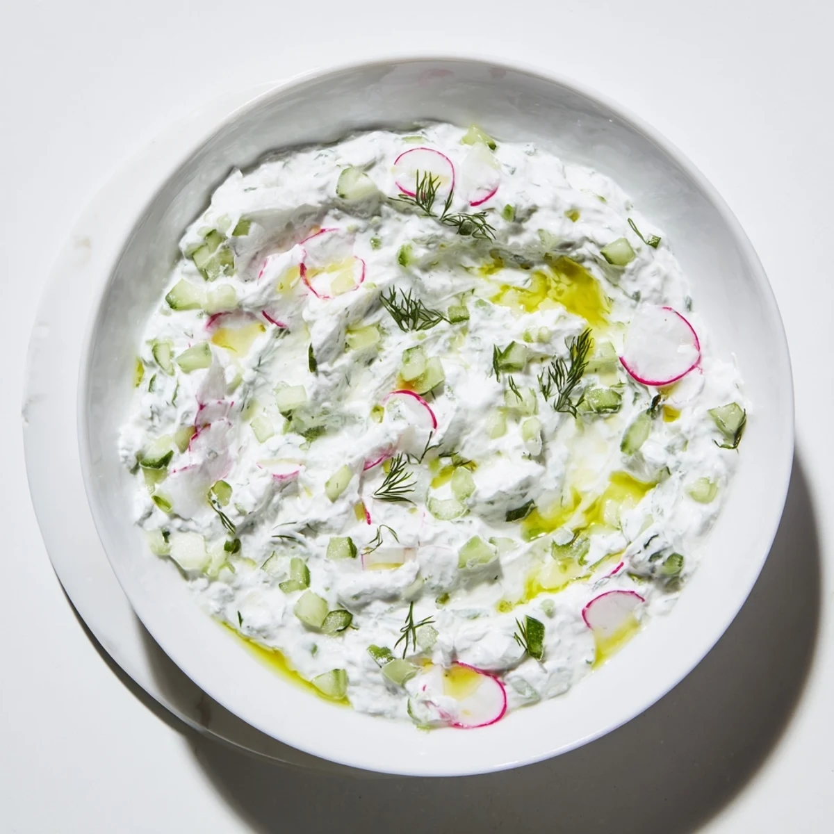 Vibrant Mediterranean healthy radish tzatziki dip garnished with mint and olive oil drizzle