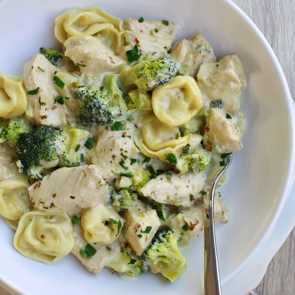 Creamy Garlic Parmesan Tortellini Chicken Broccoli Recipe served hot with grated Parmesan