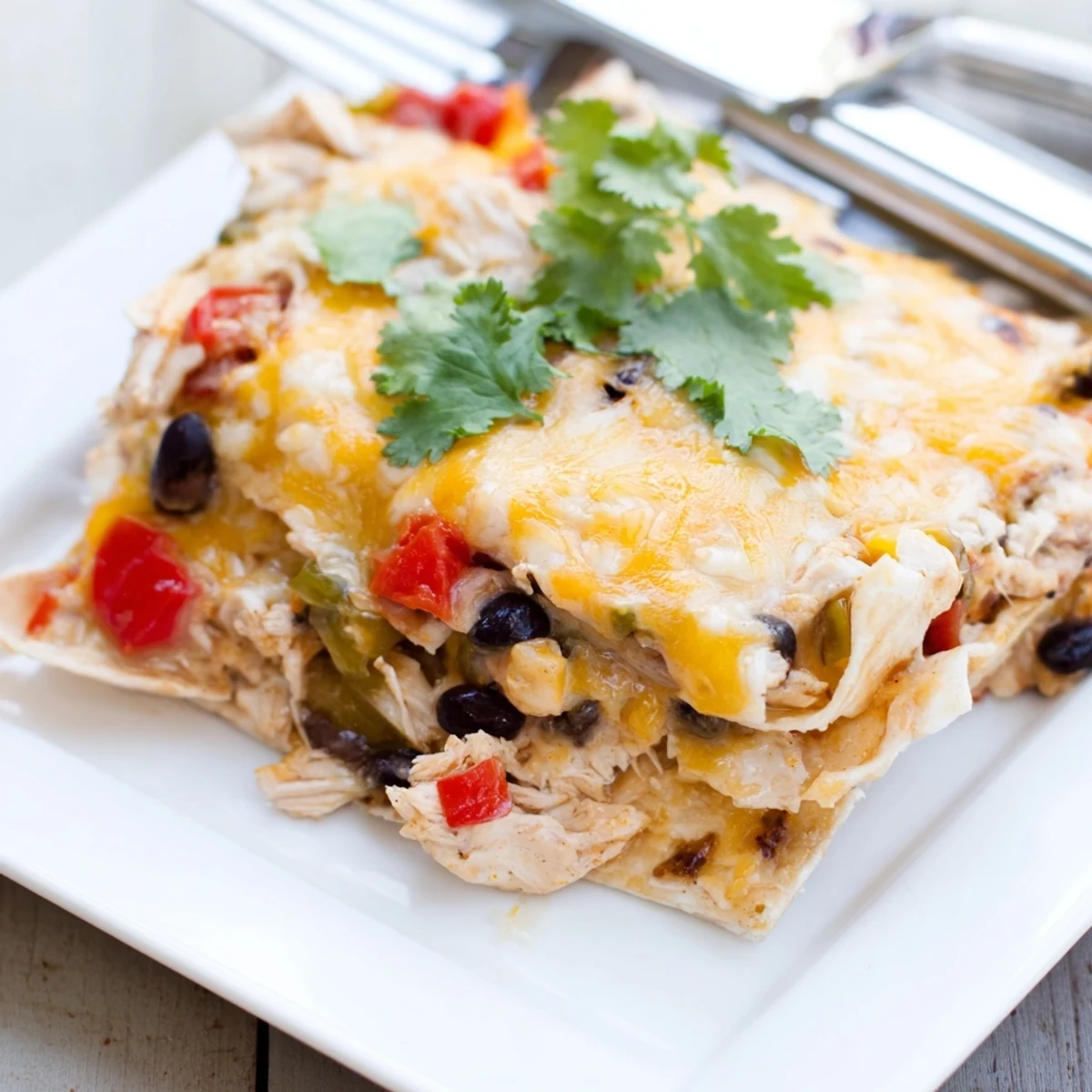 Golden bubbly cheese melted over layered creamy chicken taco lasagna in a glass baking dish