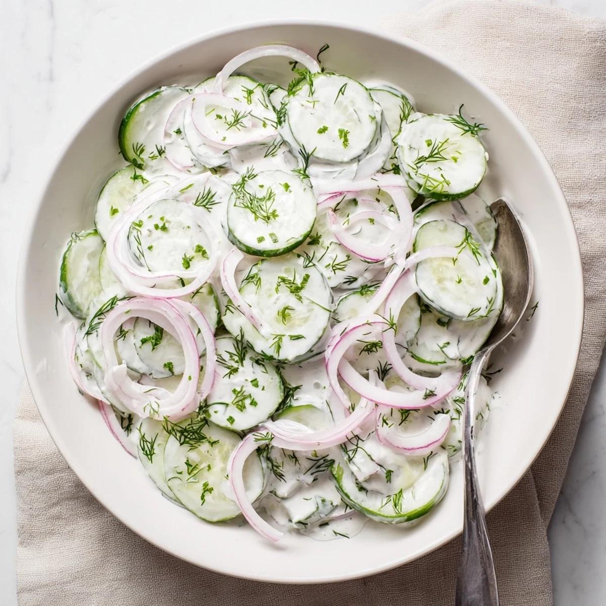 Fresh cucumber dill salad with thinly sliced vegetables and tangy cream dressing