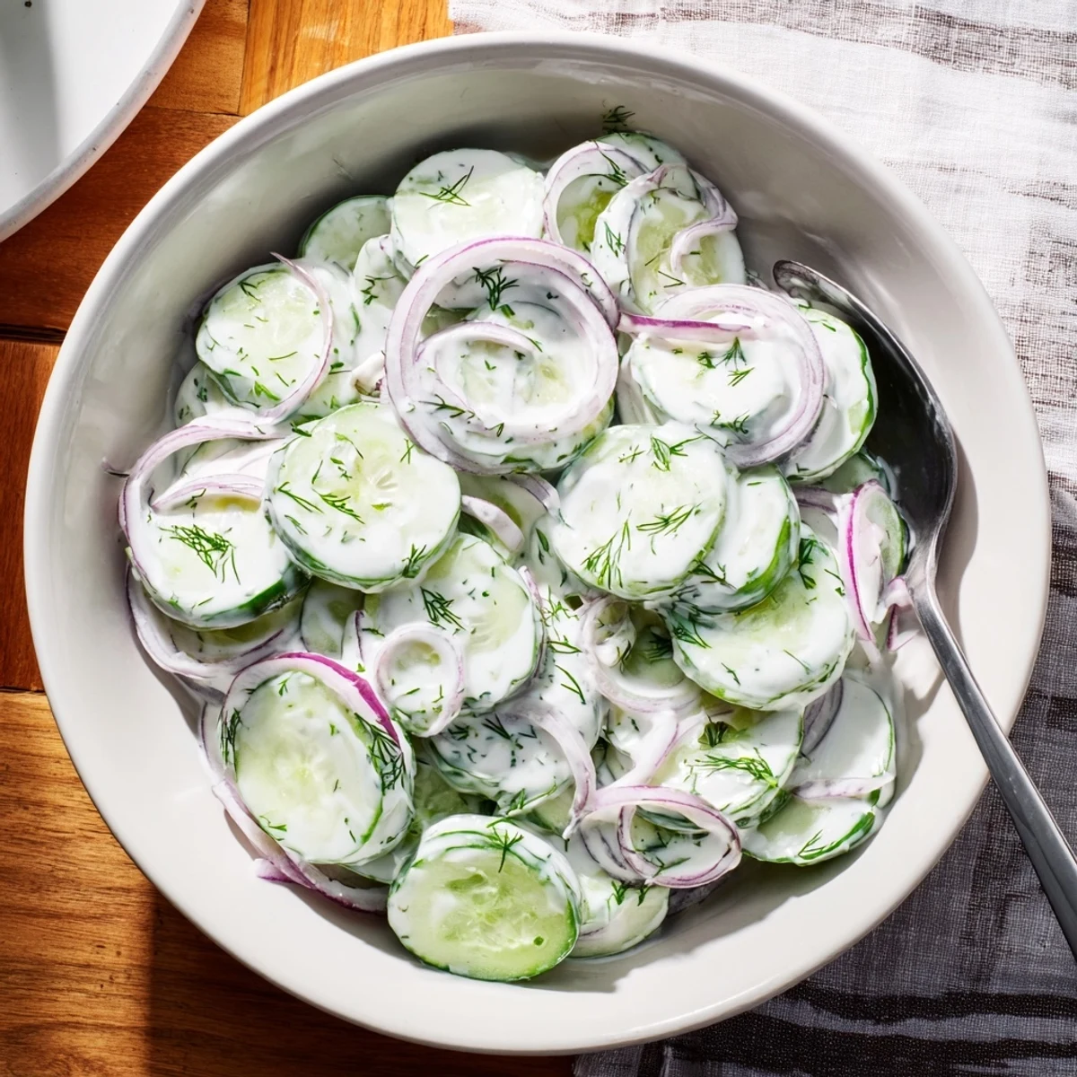 Creamy cucumber dill salad served chilled with colorful cucumber slices and dill garnish