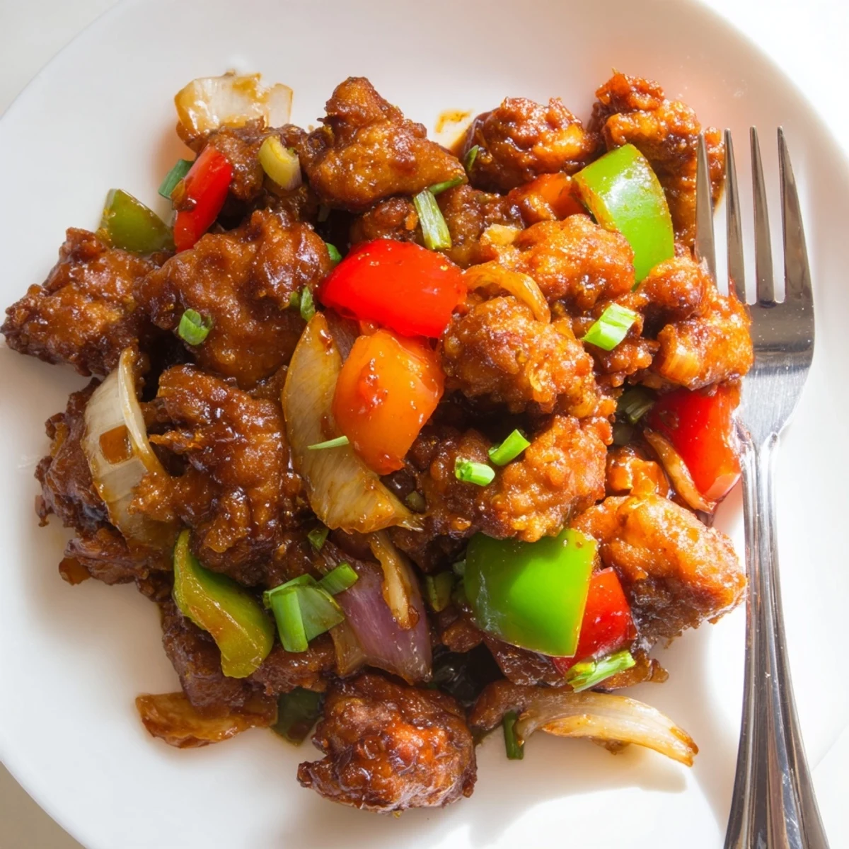 Stir-fried Flavorful Chilli Chicken Indo Chinese sizzling with peppers and scallions.