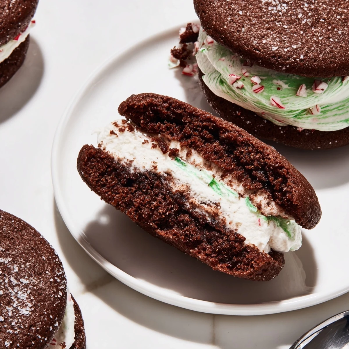 A close-up of Chocolate Peppermint Sandwich Cookies with crushed candy cane edges