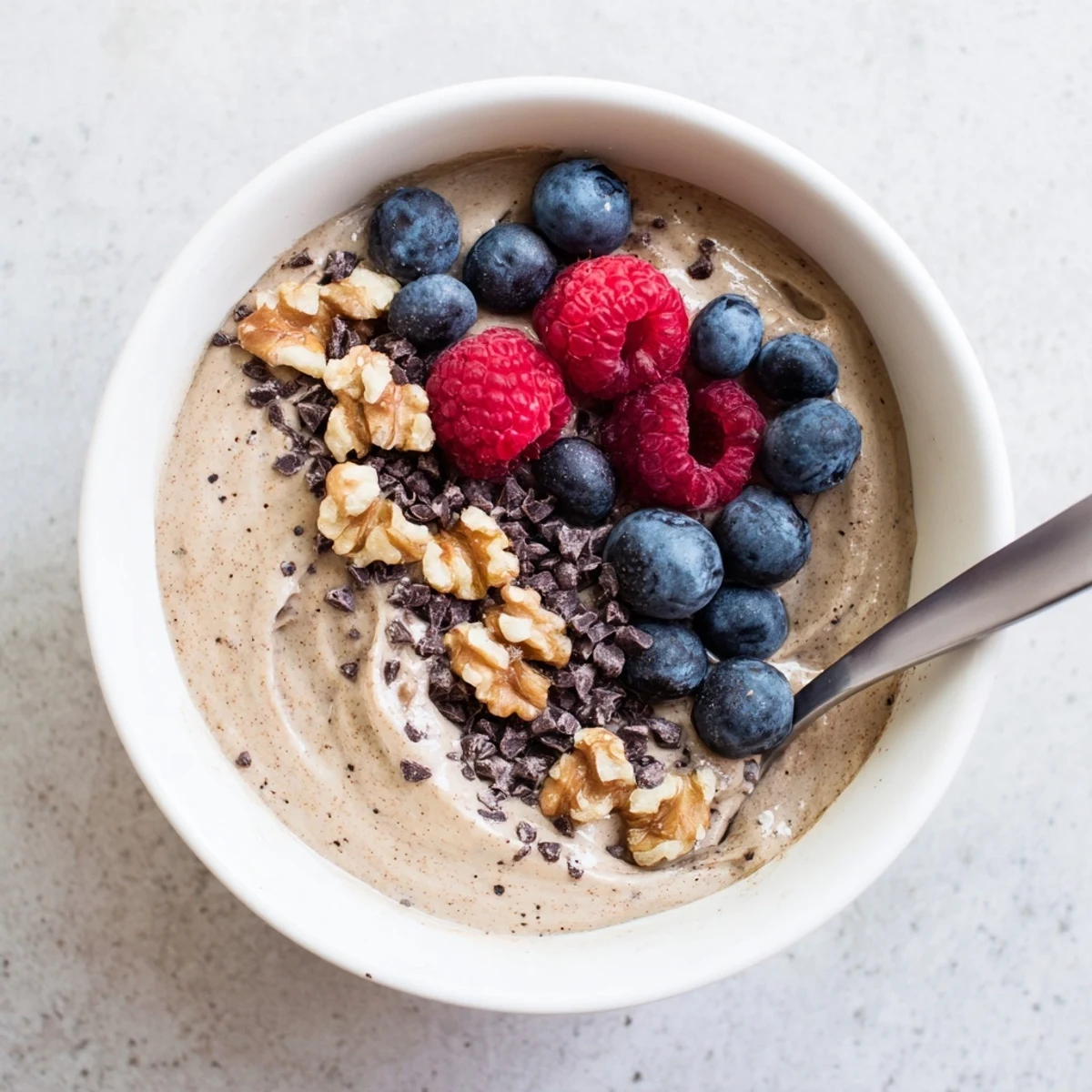 Dairy-free banana nice cream with smooth soft-serve texture in a glass dessert dish