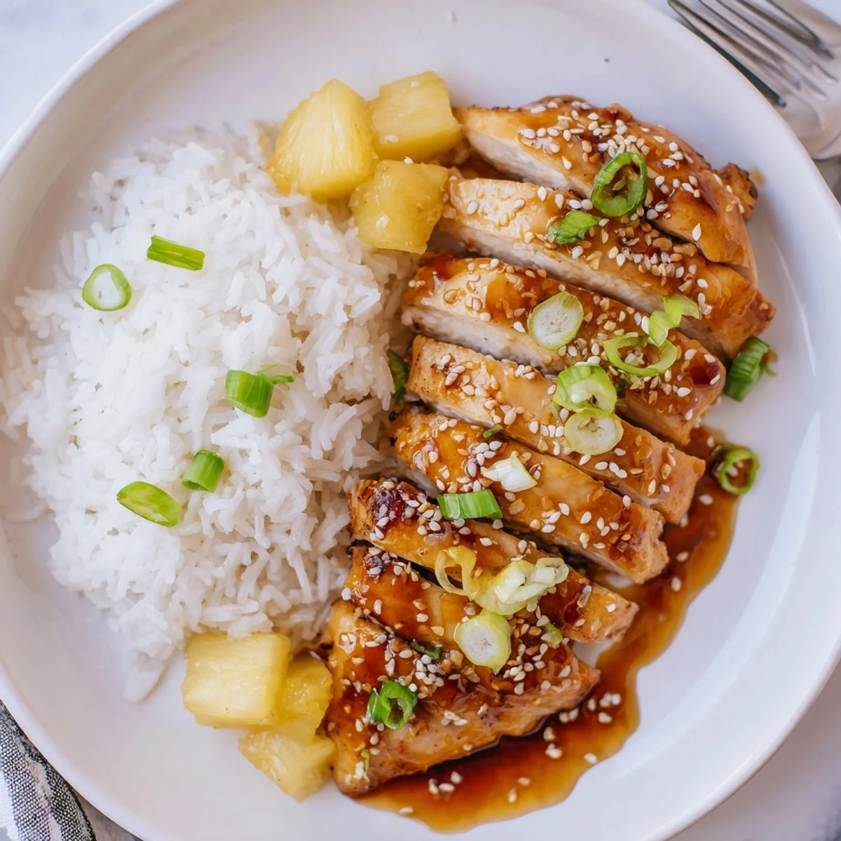Hawaiian Chicken With Coconut Rice plated, glossy pineapple glaze over tender sliced chicken.