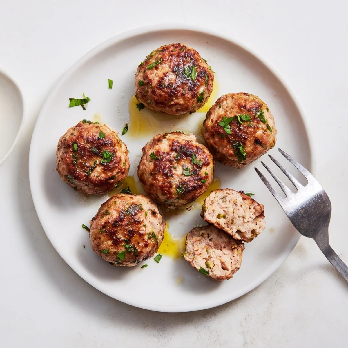 Oven-finished Juicy Chicken Meatballs, golden-crisp exterior, parsley garnish, ready to eat