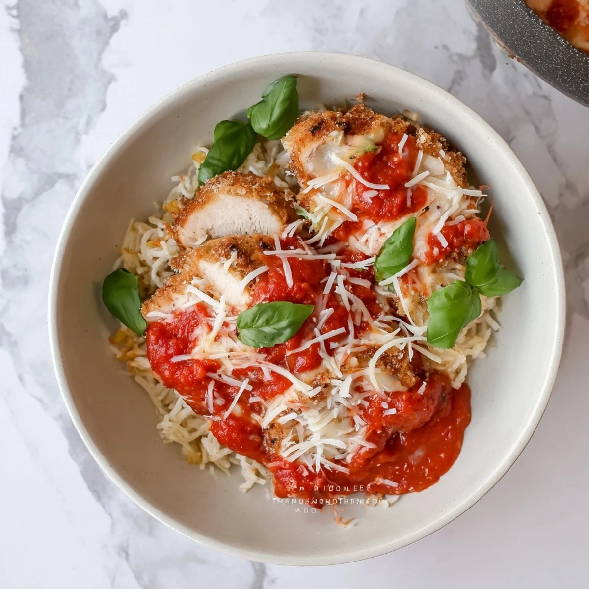 High-protein cottage cheese chicken parmesan bowl featuring juicy baked chicken with savory tomato sauce and gooey melted mozzarella topping
