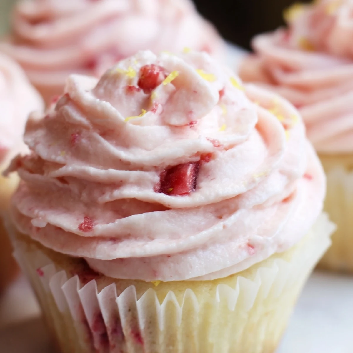 Fresh strawberry lemonade cupcakes with zesty lemon curbs and smooth strawberry buttercream swirled on top