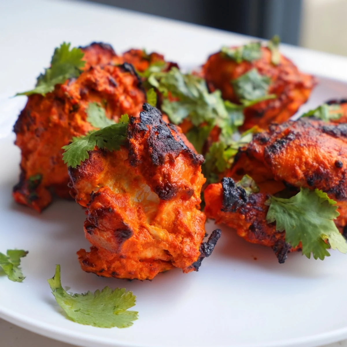 Homemade tandoori chicken yogurt spice served on a rustic wooden board with melted butter brushing and fresh herb accents