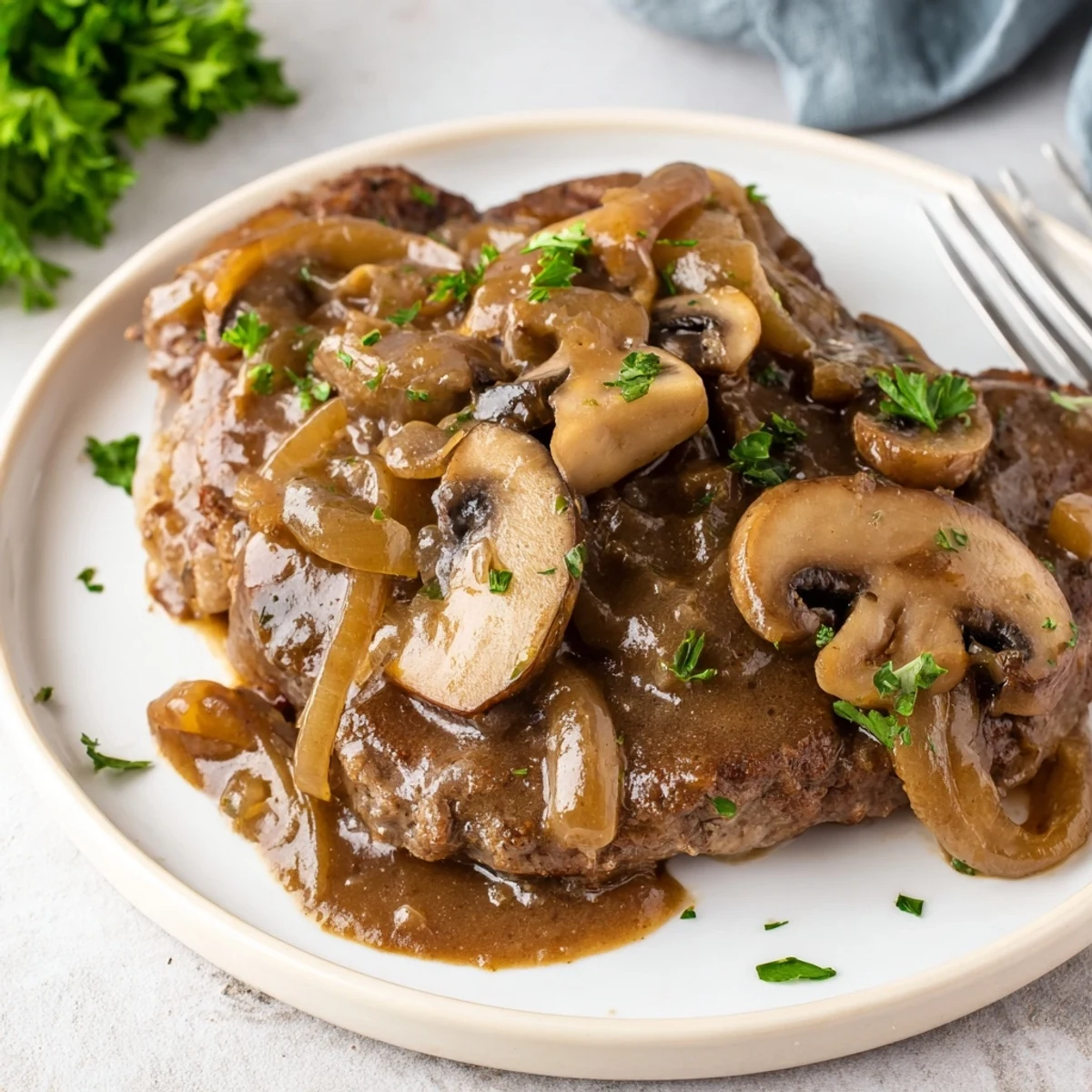 Tender country style smothered cube steak served over creamy mashed potatoes with thick brown gravy